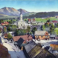 Widok na Zakopane z górami w tle, kościołem i tradycyjnymi willami.