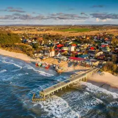 Idealne miejsce, gdzie nad morze z dzieckiem: piaszczysta plaża, molo, kolorowe łodzie i urokliwe domki.