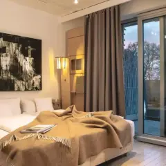 Nowoczesny pokój z dużym łóżkiem, abstrakcyjnym obrazem i widokiem na jezioro. Idealne miejsce na relaks w hotelach dla dorosłych.