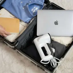 Pakowanie Wizzair bagaż podręczny: koszula, spodnie, książka, laptop i podręczny parownica.