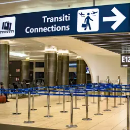 Znaki "Uscita Exit" i "Transiti Connections" na lotnisku Fiumicino. Puste kolejki do kontroli bezpieczeństwa.