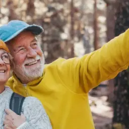 Szczęśliwi seniorzy na wczasach w górach z wyżywieniem, podziwiający widoki.