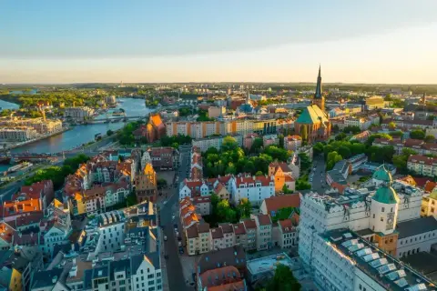 Widok z lotu ptaka na piękne Stare Miasto w Szczecinie, gdzie rzeka Odra przepływa przez miasto, a słońce zachodzi nad zabytkowymi budynkami.