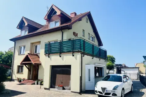 Urocze miejscowosci nad morzem, gdzie domki z balkonami i samochodami czekają na gości.