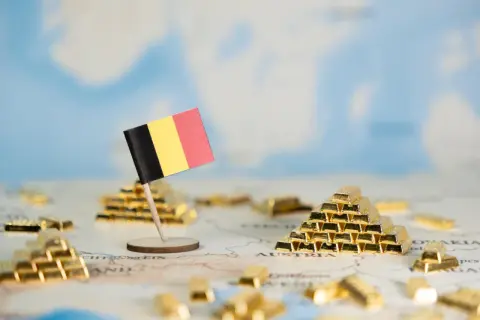 Flaga Belgii na tle mapy Europy z sztabkami złota.
