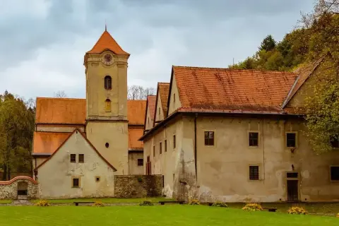 Czerwony Klasztor z wieżą zegarową i pomarańczowymi dachami. Sprawdź cennik zwiedzania tego zabytku.