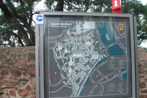 Mapa turystyczna "Stadt Meißen Historische Altstadt" przedstawia urokliwe porcelanowe miasto w Saksonii, z zaznaczonymi zabytkami i rzeką Łabą.