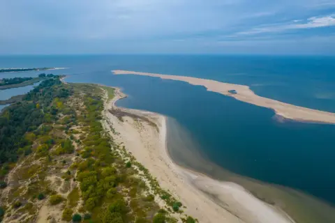 Piękne krajobrazy nad morzem bałtyckim. Miejscowości nad zatoką, piaszczyste plaże i zielone wydmy tworzą malowniczy widok.