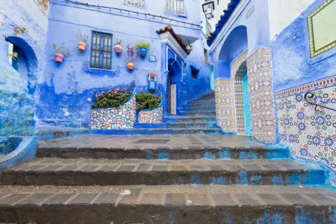 Niebieskie miasto w Maroku, Chefchaouen, zachwyca kolorowymi mozaikami i kwitnącymi roślinami.