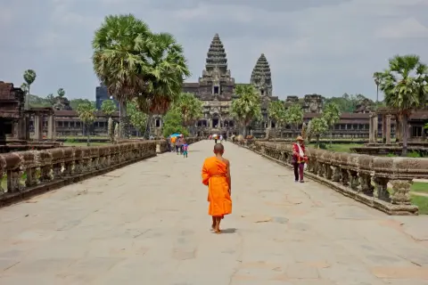 Mnich w pomarańczowej szacie idzie do Angkor Wat, wspaniałego miejsca na kambodżańskie wakacje.