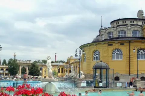 Budapeszt termy cennik: Kąpiel w basenie zewnętrznym przy zabytkowych budynkach, relaks w wodzie.