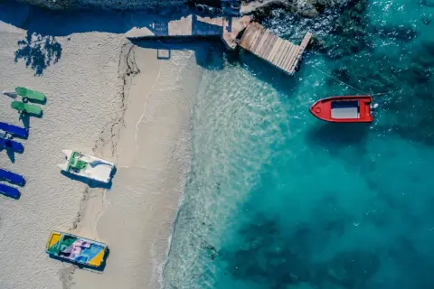 Idealne miejsce, gdzie w styczniu na wakacje: pusta plaża, turkusowa woda i łodzie czekające na przygodę.