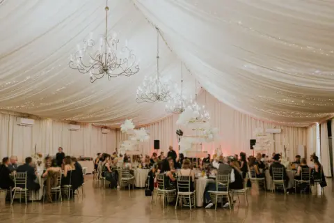 Elegancka sala bankietowa z żyrandolami i światełkami, idealna do organizacji wyjazdów na konferencje i wycieczki firmowe.