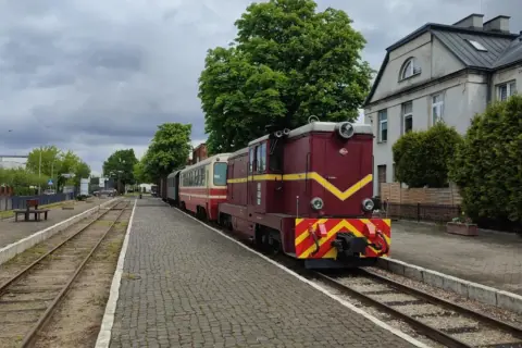 Czerwona lokomotywa z wagonami na stacji w Piasecznie. Idealne piaseczno atrakcje na weekend dla miłośników kolei.
