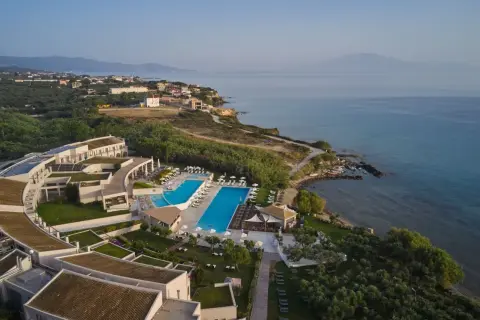 Hotel Pelagos Zante, z basenami i widokiem na morze, otoczony zielenią i gajami oliwnymi.