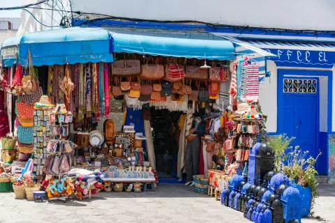 Kolorowy sklep z pamiątkami w Tunezji. W ofercie skórzane torby, szale, lampy i inne rękodzieło. Ceny w Tunezji są tu atrakcyjne.