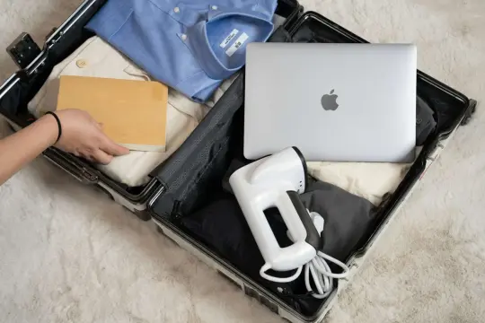 Pakowanie Wizzair bagaż podręczny: koszula, spodnie, książka, laptop i podręczny parownica.