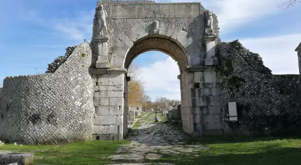 Starożytny łuk w Bojano, z kamienną drogą prowadzącą do ruin.
