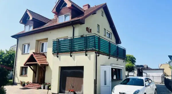 Urocze miejscowosci nad morzem, gdzie domki z balkonami i samochodami czekają na gości.
