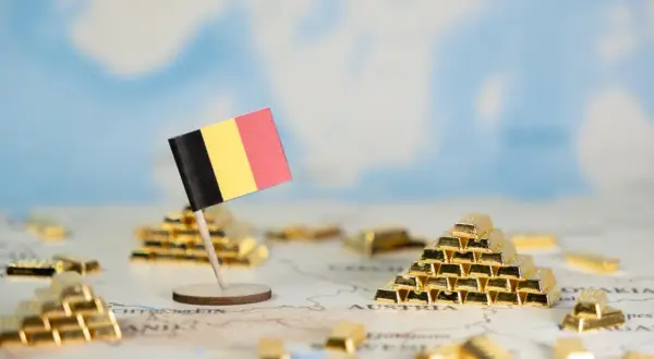 Flaga Belgii na tle mapy Europy z sztabkami złota.