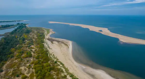 Piękne krajobrazy nad morzem bałtyckim. Miejscowości nad zatoką, piaszczyste plaże i zielone wydmy tworzą malowniczy widok.
