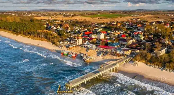 Idealne miejsce, gdzie nad morze z dzieckiem: piaszczysta plaża, molo, kolorowe łodzie i urokliwe domki.