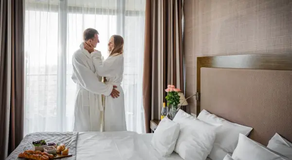 Para spędza romantyczny poranek w szlafrokach, delektując się śniadaniem. Idealny **spa nad morzem dla dwojga**.