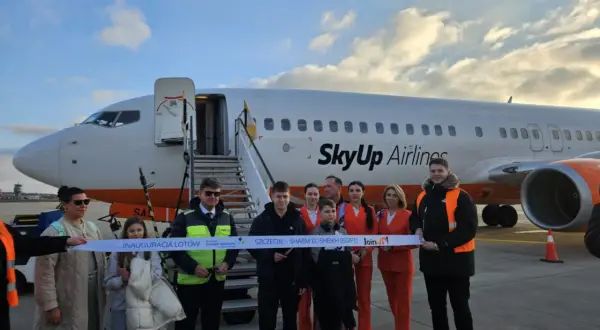 Grupa osób przecina wstęgę przed samolotem SkyUp Airlines. Inauguracja lotów do Szarm El-Szejk. Lotnisko nad morzem.