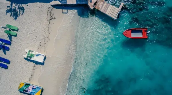 Idealne miejsce, gdzie w styczniu na wakacje: pusta plaża, turkusowa woda i łodzie czekające na przygodę.
