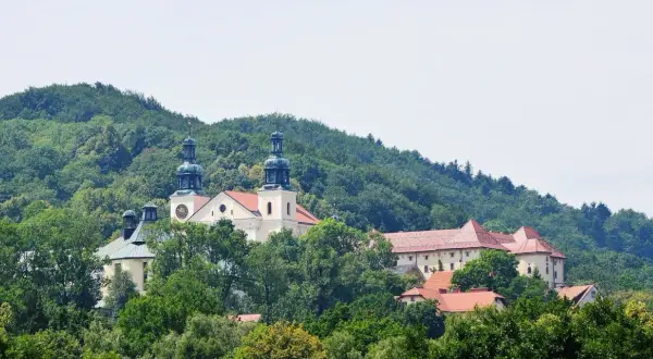 Wzgórza porośnięte lasem otaczają klasztor, który przepływa przez Kalwarię Zebrzydowską.