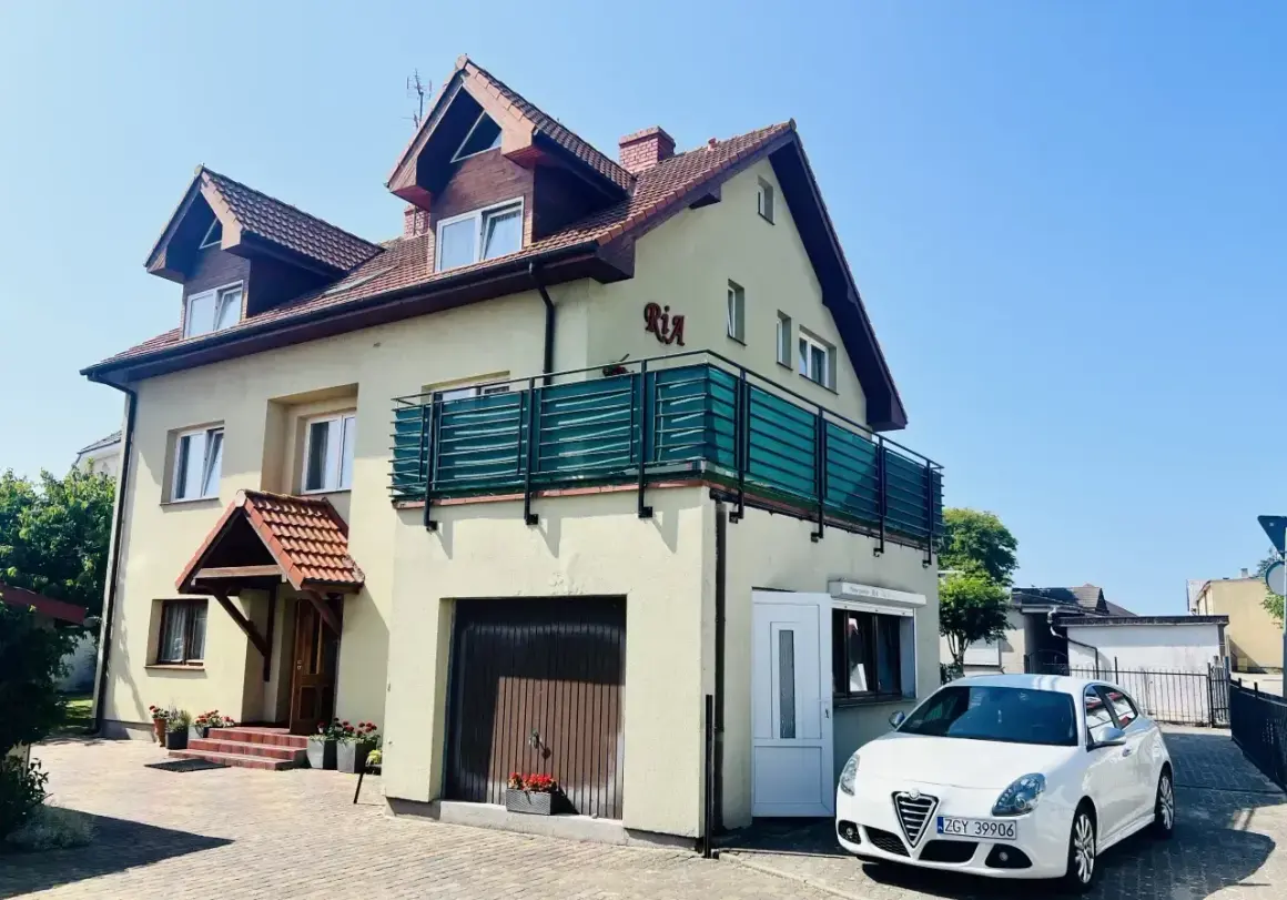 Urocze miejscowosci nad morzem, gdzie domki z balkonami i samochodami czekają na gości.