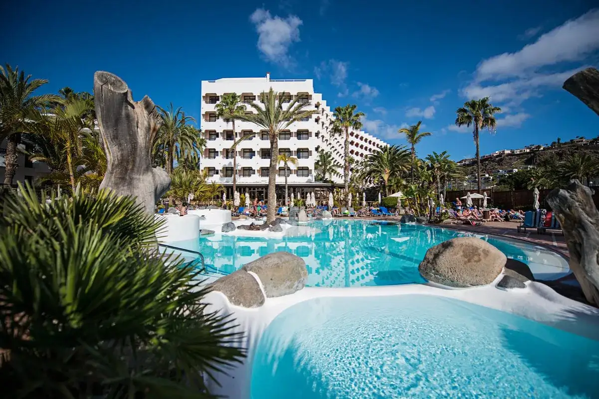 Słoneczny dzień w San Agustin, Gran Canaria. Hotel z basenem i palmami, idealne miejsce na relaks.