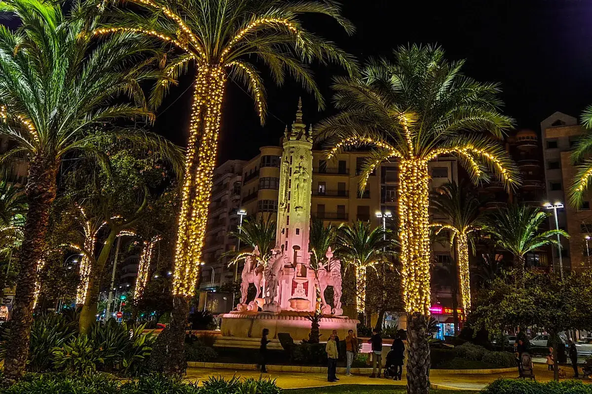 Nocna iluminacja palm i fontanny z rzeźbami. Wspaniałe święta w Hiszpanii, pełne blasku i magii.
