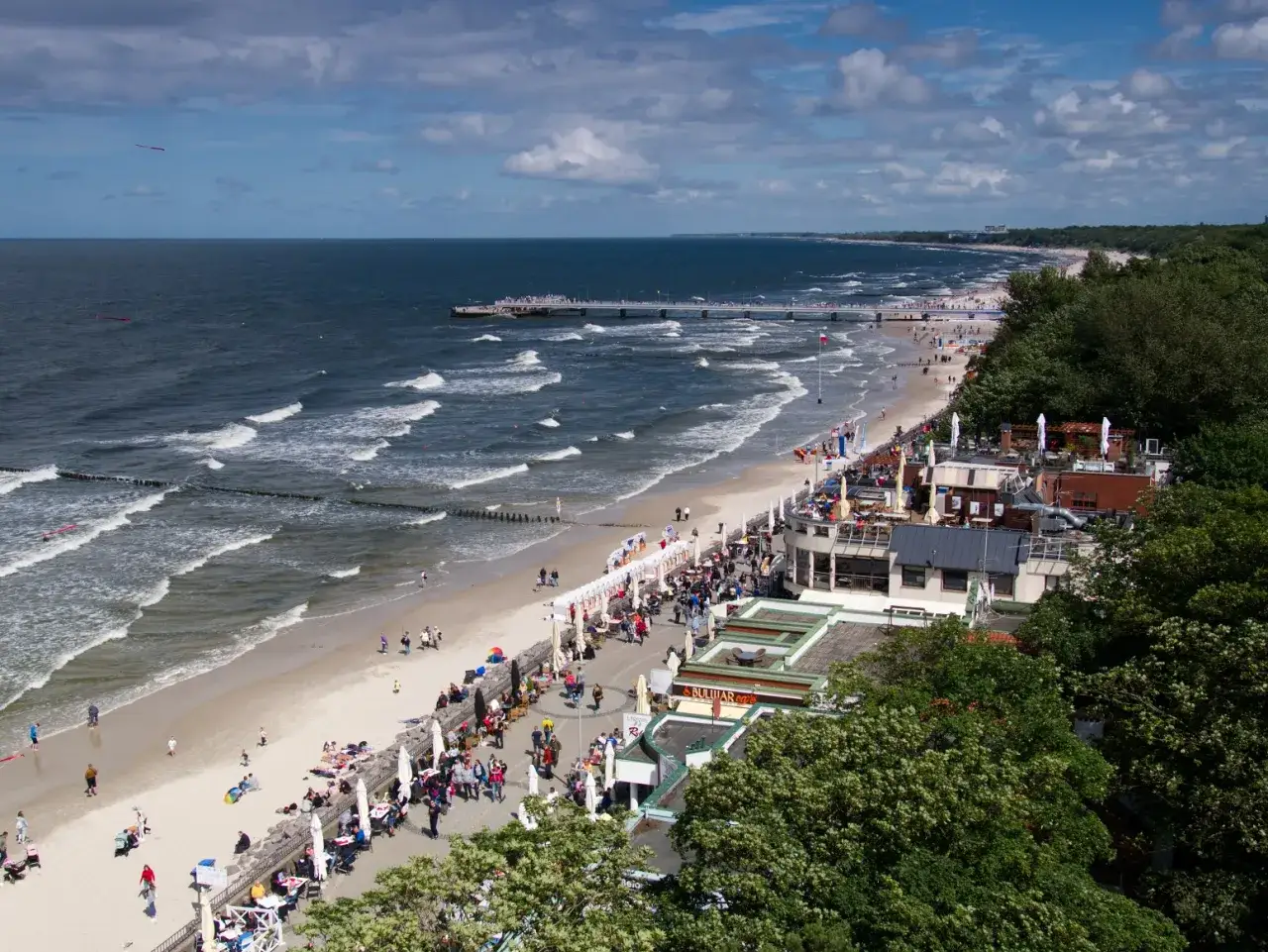 Tętniące życiem miejscowosci nad morzem z piaszczystą plażą, molo i licznymi kawiarniami.