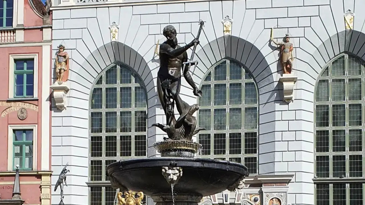 Fontanna Neptuna w Gdańsku, symbol miasta. Neptun z trójzębem góruje nad mitycznymi stworzeniami. Długa historia tego miejsca.