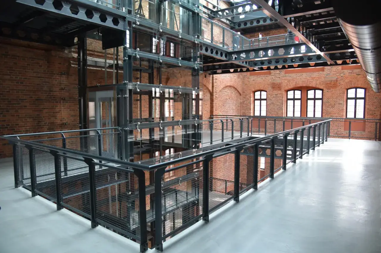 Nowoczesna winda w industrialnym wnętrzu z ceglanymi ścianami. Nietypowe atrakcje Bydgoszcz czekają!