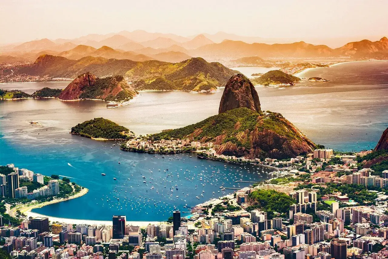 Widok na Rio de Janeiro z górą Głowa Cukru. Czy do Brazylii potrzebna jest wiza? Turyści podziwiają panoramę miasta i zatoki pełnej łodzi.