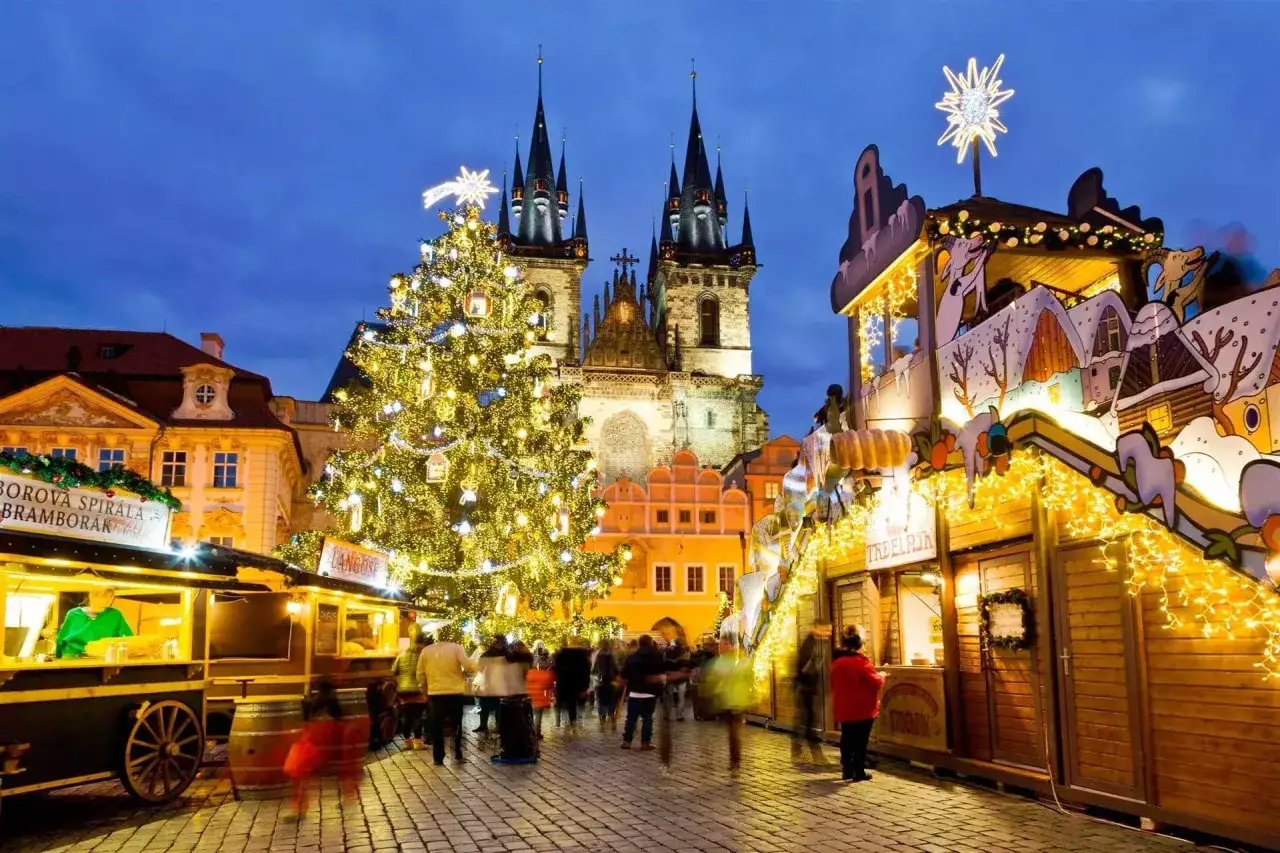 Targ bożonarodzeniowy w Pradze, Czechy. Rozświetlona choinka i stragany tworzą magiczną atmosferę.