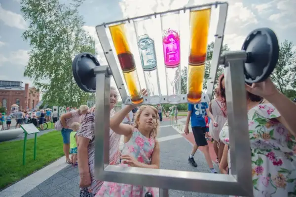 Dzieci i dorośli bawią się interaktywną instalacją z kolorowymi płynami. Siemianowice wydarzenia pełne radości i nauki.