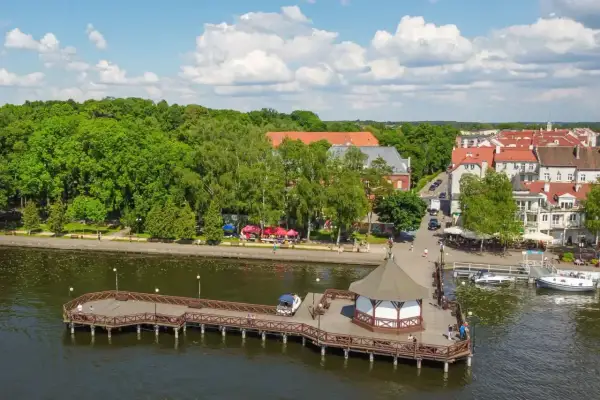 Idealny weekend na Mazurach: malownicza promenada, urokliwa przystań i uśmiechnięci ludzie cieszący się słońcem.