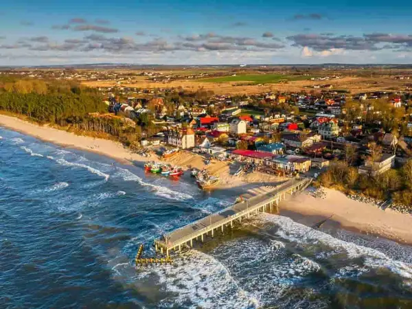 Idealne miejsce, gdzie nad morze z dzieckiem: piaszczysta plaża, molo, kolorowe łodzie i urokliwe domki.