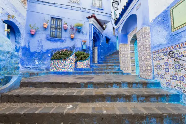 Niebieskie miasto w Maroku, Chefchaouen, zachwyca kolorowymi mozaikami i kwitnącymi roślinami.