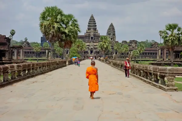 Mnich w pomarańczowej szacie idzie do Angkor Wat, wspaniałego miejsca na kambodżańskie wakacje.