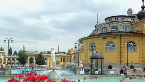Budapeszt termy cennik: Kąpiel w basenie zewnętrznym przy zabytkowych budynkach, relaks w wodzie.