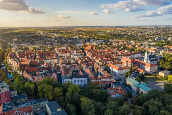 Widok z lotu ptaka na zabytkowe centrum Kalisza, najstarszego miasta w Polsce, z charakterystyczną czerwoną dachówką i wieżami kościołów.